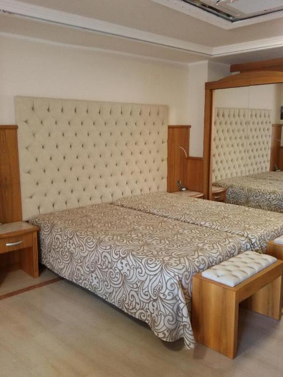 Mūsdienīga guļamistaba ar diviem gultas matračiem, apgaismojumu un spoguli, kas atspoguļo komfortu un eleganci. Guļamistabas interjers ir veidots ar dabīgā koka akcentiem un stilīgu tekstilu.