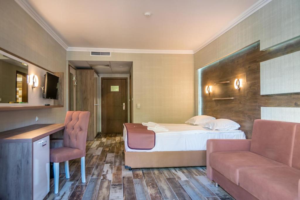 Mūsdienīgs viesnīcas numurs ar ērtu gultu, dīvānu un rakstāmgaldu, kas apgaismots ar mūsdienīgām lampām. Ideāla vieta atpūtai un darbam.