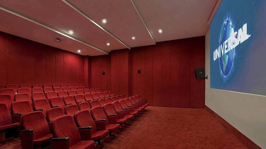 Sarkanas krēslus ar ekrānu, uz kura redzams 