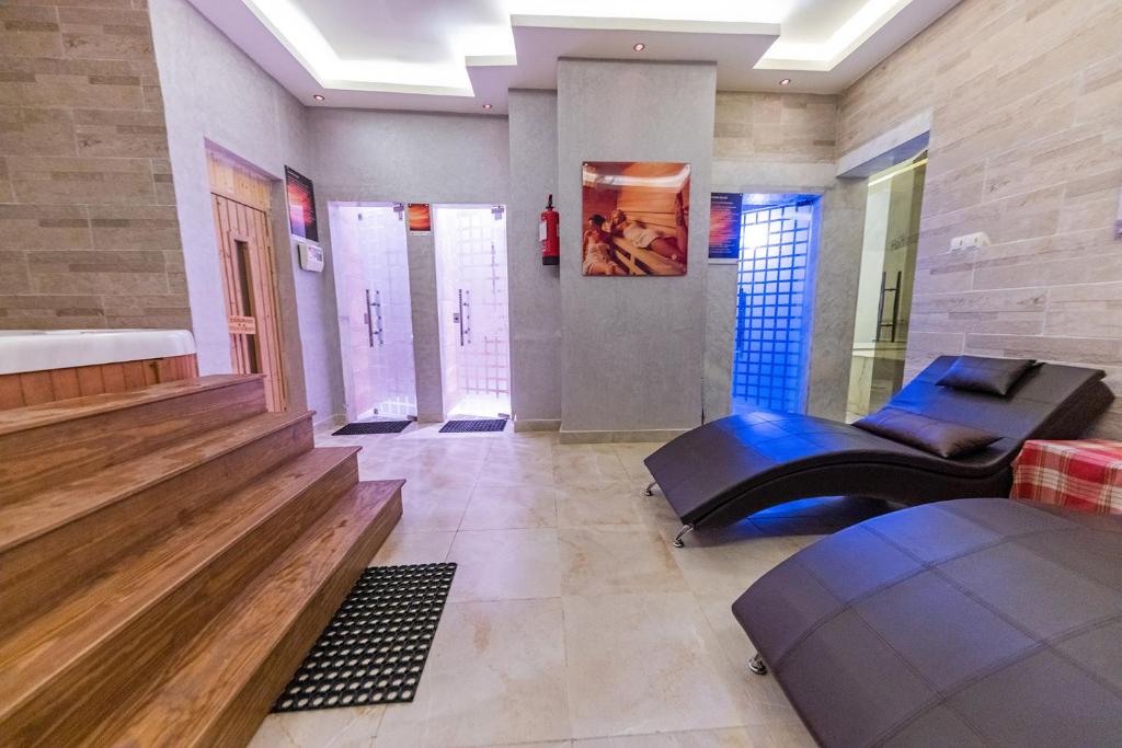 Spa telpa ar koka pakāpieniem, atpūtas krēsliem un divām dušām. Moderns interjers ar mīkstu apgaismojumu un relaksējošu atmosfēru.