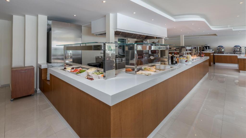 Mūsdienīgs bufetes stils restorāns ar plašu ēdienu izvēli, ieskaitot svaigus dārzeņus un gaļu, gaišā un eleganta interjerā.