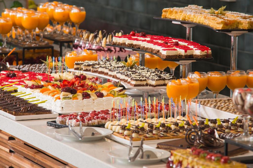 Deserts un kokteiļi svinību galda klājumā, ieskaitot kūkas, augļu salātus un krāsainus dzērienus. Lieliska izvēle svinībām vai svētkiem.