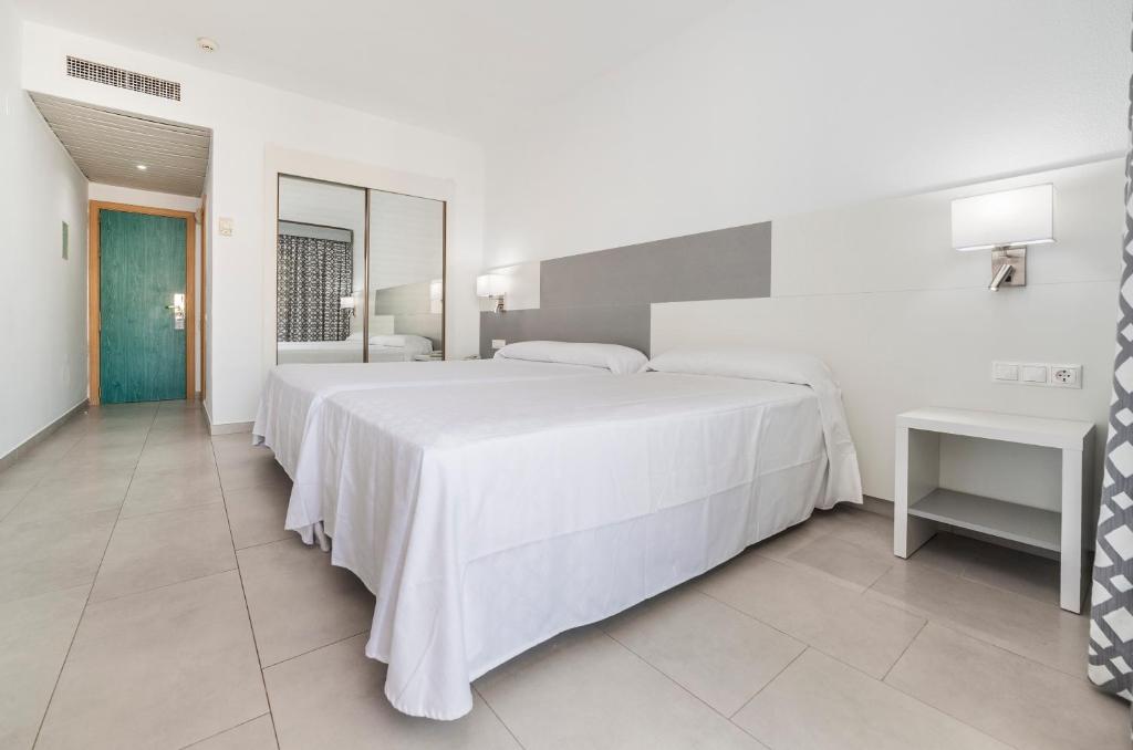 Mūsdienīgs viesnīcas numurs ar divām gultām, gaišām sienām un minimālistisku interjeru. Numurā ir liels spogulis un galda lampa, radot ērtu un patīkamu atmosfēru.