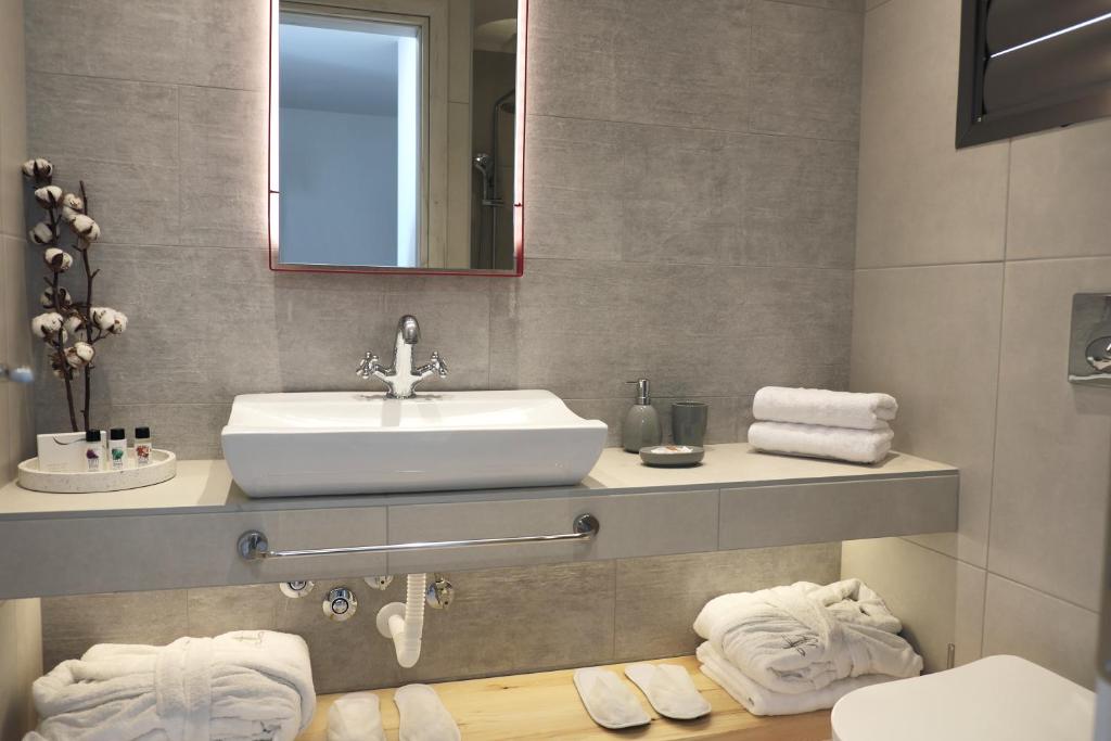 Moderns vannas istabas interjers ar baltu izlietni, spoguli un mīkstām dvielīšiem. Dekorēts ar kokvilnas ziediem un kosmētikas produktiem.