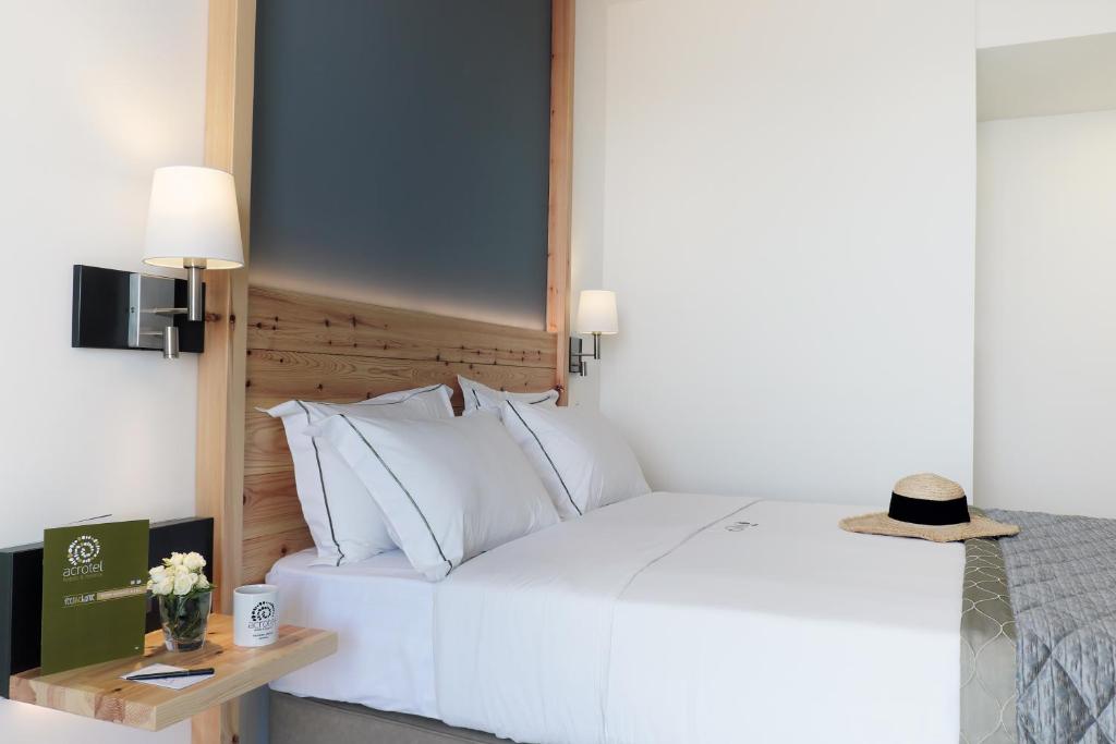 Mūsdienīgs viesnīcu numurs ar ērtu gultu, koka detaļām un mīkstiem spilveniem. Uz galda ir ziedi un viesnīcas informācijas buklets.