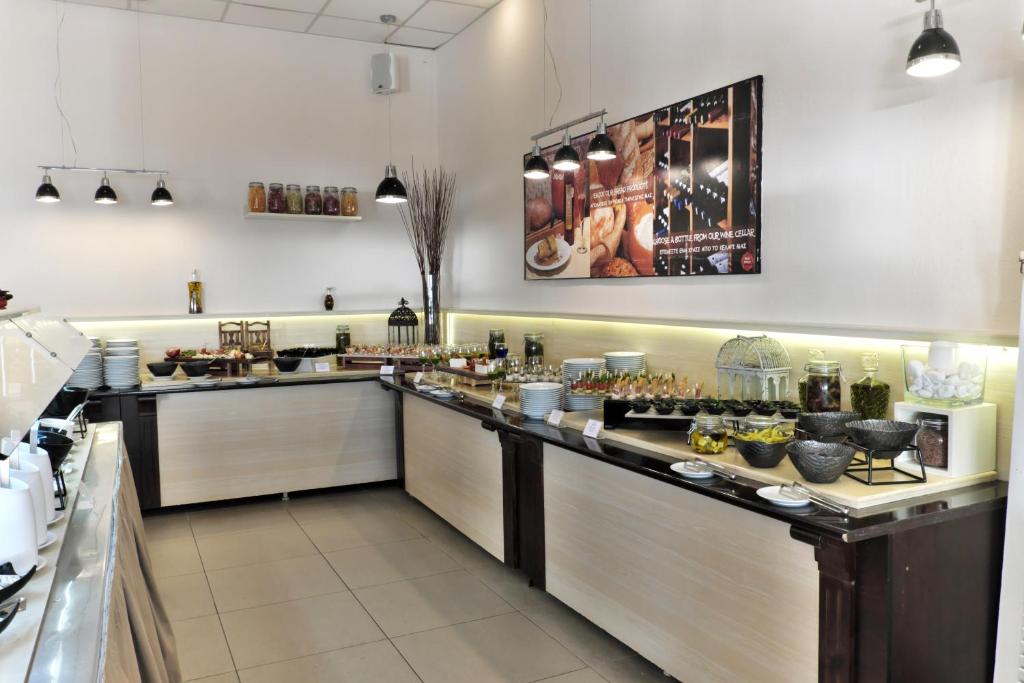 Brokastu bufete ar dažādiem ēdieniem, kas sakārtoti uz galda, apgaismojums un dekorācijas veido patīkamu atmosfēru.