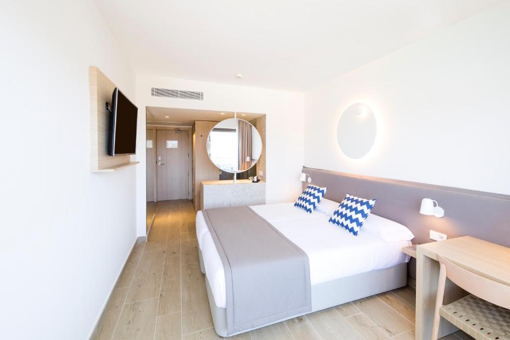 Mūsdienīgs viesnīcas numurs ar divām gultām, stilīgiem spilveniem un televizoru. Telpa ir gaiša un plaša, ar koka grīdu un modernu interjeru.