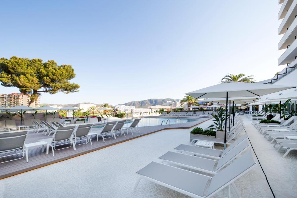 Peldbaseins ar saulessargiem un atpūtas krēsliem, apzaļumota teritorija un kalnu ainava fona. Ideāla vieta relaksācijai un atpūtai.