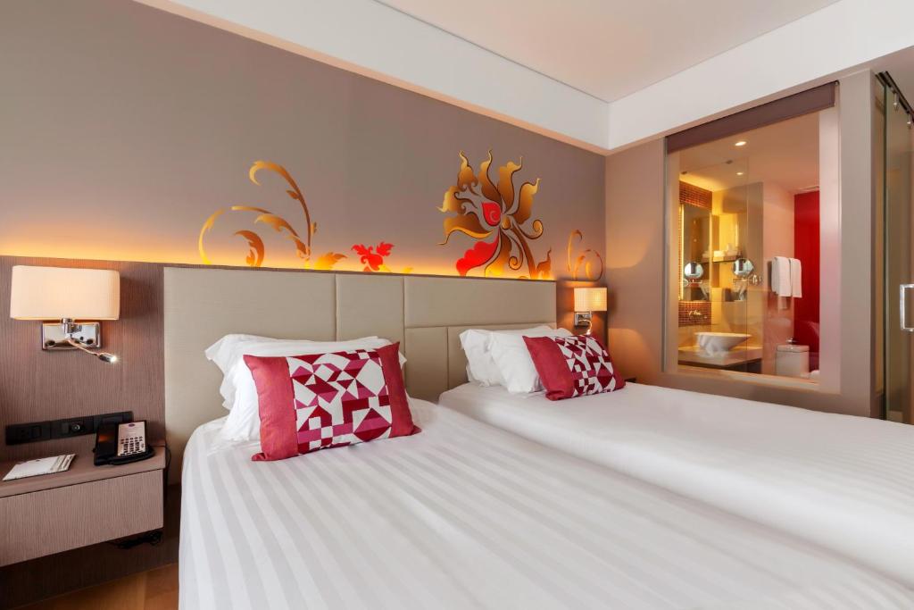 Moderns numurs ar divām gultām Grand Mercure Phuket Patong, ar dekoratīvu sienu un vannas istabu.