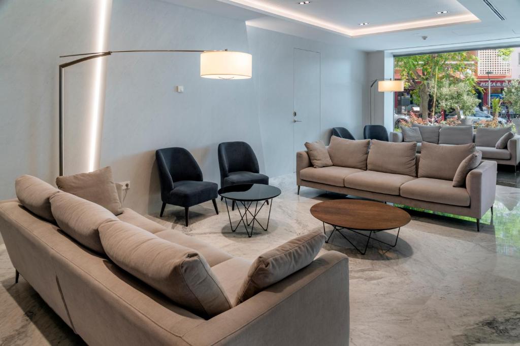 Mūsdienīga viesistaba ar ērtām pelēkām dīvāniem un krēsliem, kā arī elegantu galdu. Labi apgaismota telpa ar lieliem logiem un dabisko apgaismojumu.