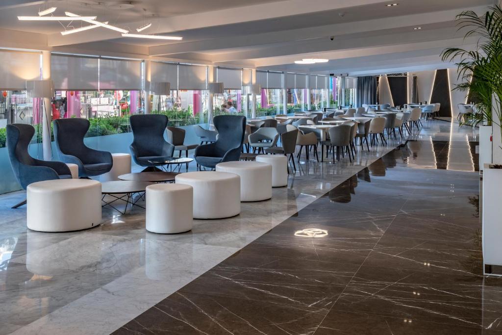 Moderns interjers ar stilīgām mēbelēm, gaišām krāsām un plašu telpu, kas paredzēta relaksācijai un ēšanai. Eleganta apgaismojuma un augu elementi rada patīkamu atmosfēru.