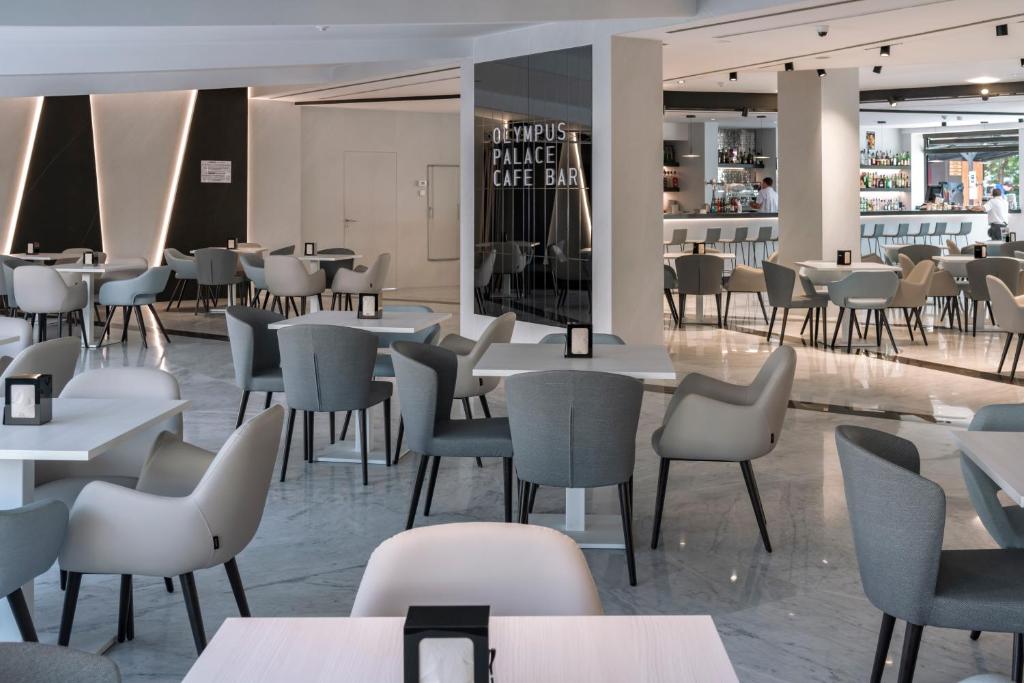 Mūsdienīgs restorāns ar elegantiem galdiem un krēsliem, apgaismots ar siltu gaismu, radot patīkamu atmosfēru. Redzams bārs ar plašu dzērienu izvēli.