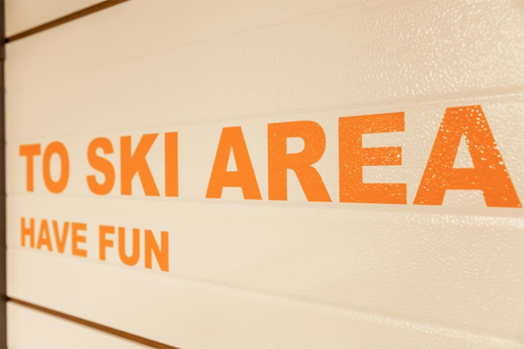 Norādījums uz slēpošanas zonu ar aicinājumu izbaudīt jautrību.