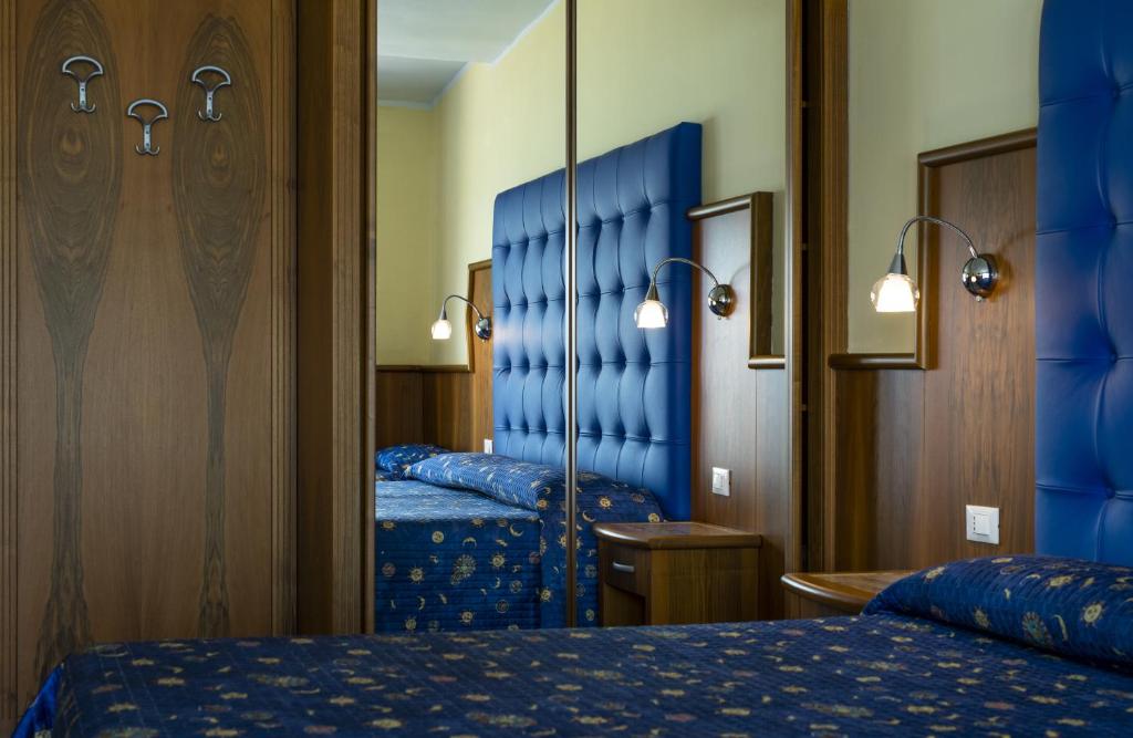 Moderna guļamistaba ar zilu audumu, koka mēbelēm un spoguļiem, kas palielina telpas izjūtu. Ideāla vieta relaksācijai un atpūtai.