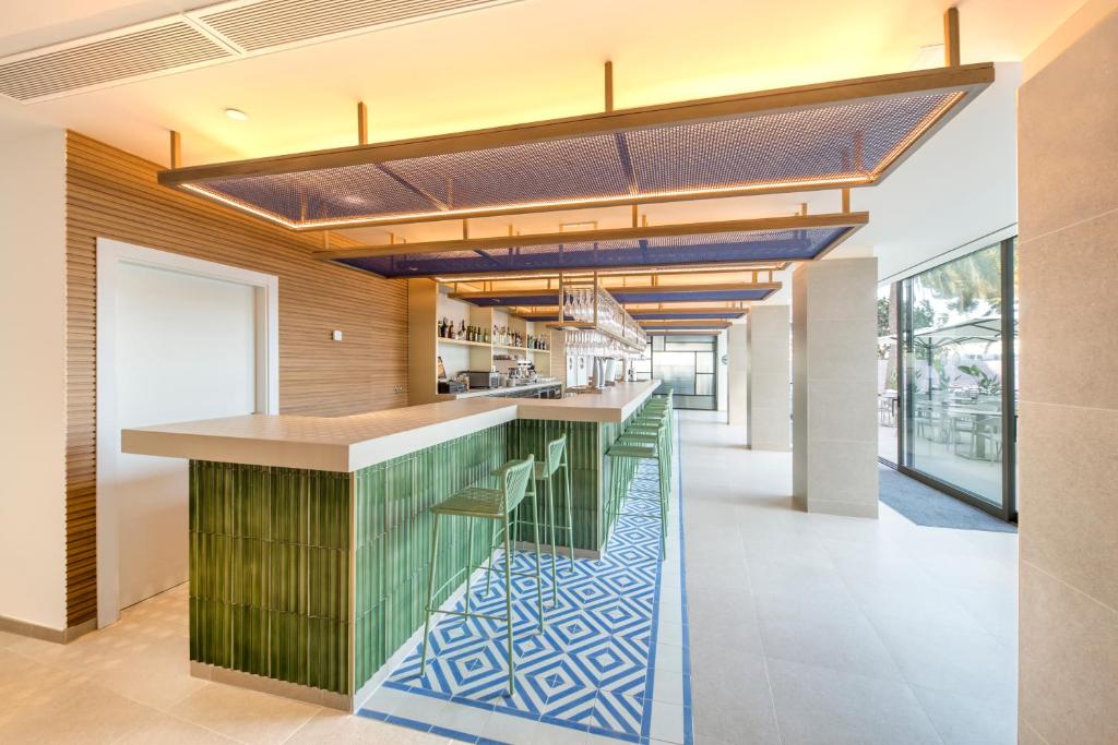 Mūsdienīgs bārs ar zaļo flīžu virsmu un stilīgu interjeru. Bāra izkārtojums ir elegants, ar stikla sienām un modernām gaismas instalācijām.