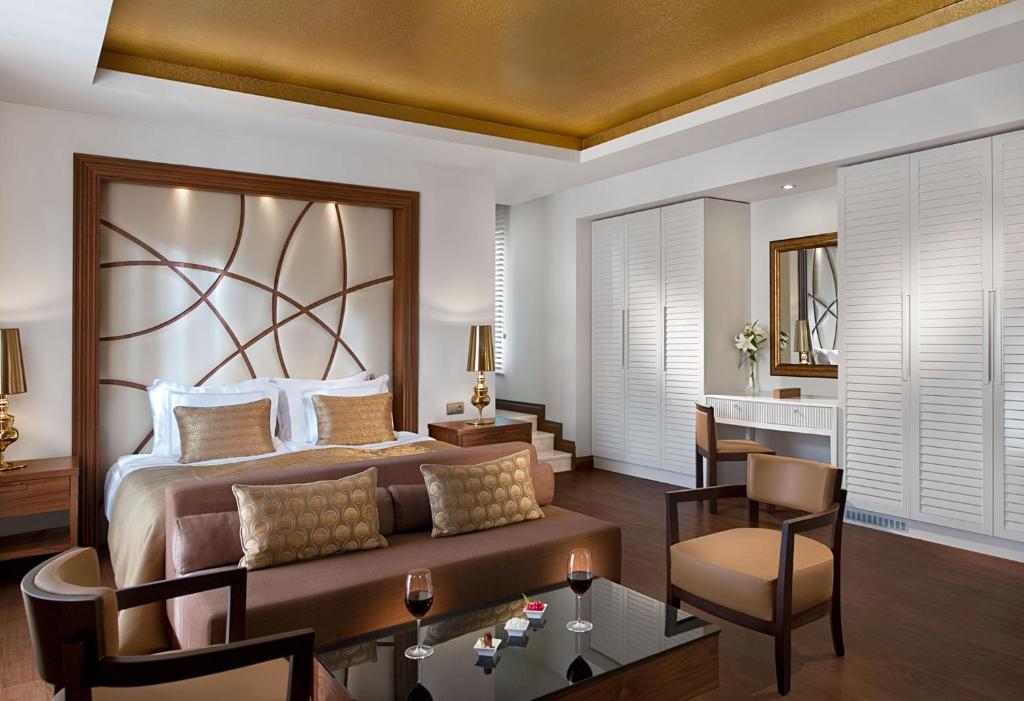 Mūsdienīgs viesnīcas numurs ar elegantu dizainu, kas ietver ērku gultu un stilīgas mēbeles. Telpā ir viesu sēdvietas un liels logu apgaismojums.