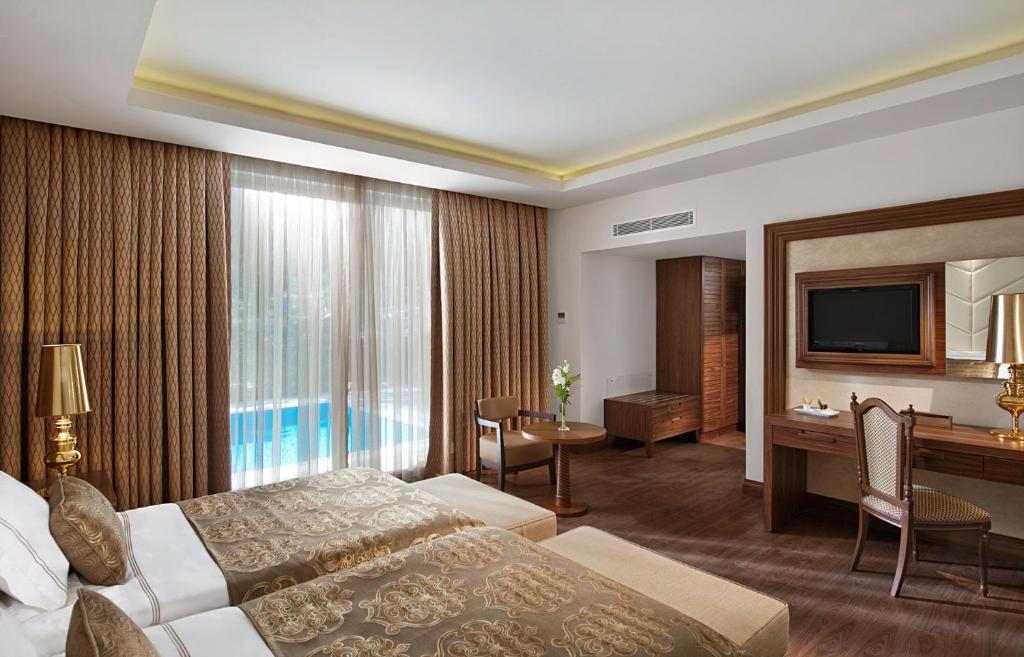 Elegants viesnīcas numurs ar divām gultām, dekorēts brūnos toņos, ar lieliem logiem, caur kuriem ieplūst dabiska gaisma. Interjerā ir moderns mēbeļu komplekts un televizors, kā arī piekļuve baseinam.