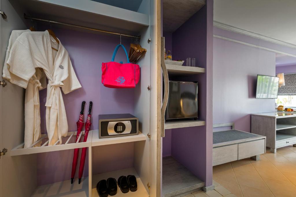 Mūsdienīgs viesnīcas numura stūris ar skapī ieliktām peldmēteļa, lietussargu un somu, kā arī mini ledusskapi un televizoru. Interjers rotāts ar violetu krāsu, radot viesmīlīgu atmosfēru.