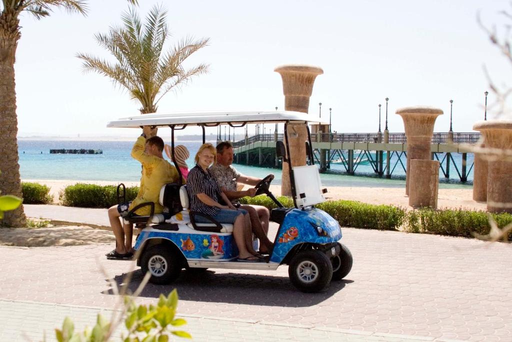 Viesi brauc ar golfa ratiņiem pie Old Palace Resort Sahl Hasheesh pludmales