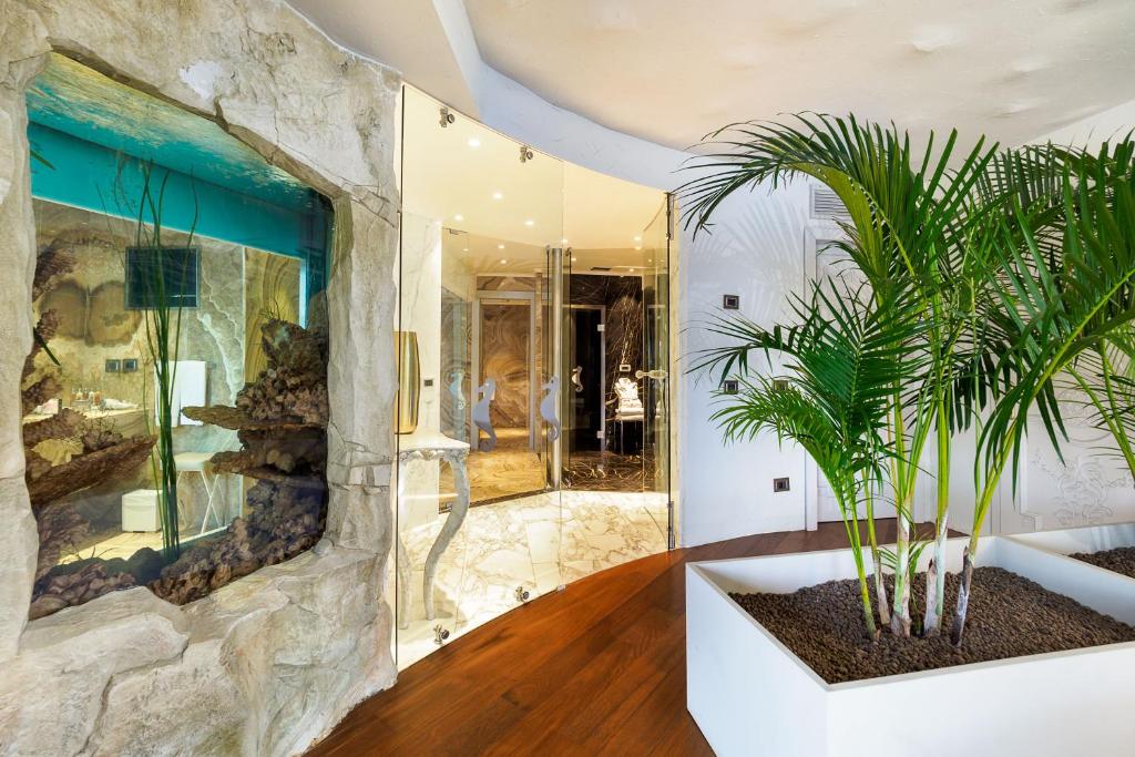 Mūsdienīgs interjers ar akvāriju un zaļumu, kas rada relaksējošu atmosfēru. Stils apvieno eleganci un dabu.