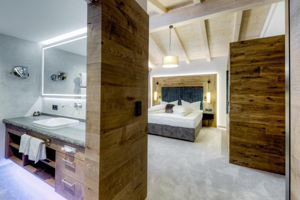 Mūsdienīgs viesnīcas numurs ar koka akcentiem, kurā ir guļamistaba un vannas istaba. Interjers izceļas ar elegantu dizainu un siltām krāsām, radot relaksējošu atmosfēru.