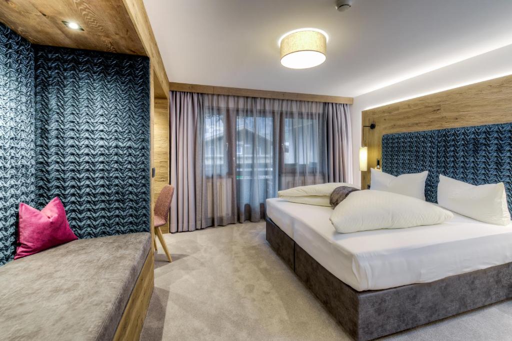 Mūsdienīgs viesnīcas numurs ar ērtu gultu, stilīgu apgaismojumu un siltu koka interjeru. Logi nodrošina dabu, bet dīvāns un spilvens piešķir papildu komfortu.