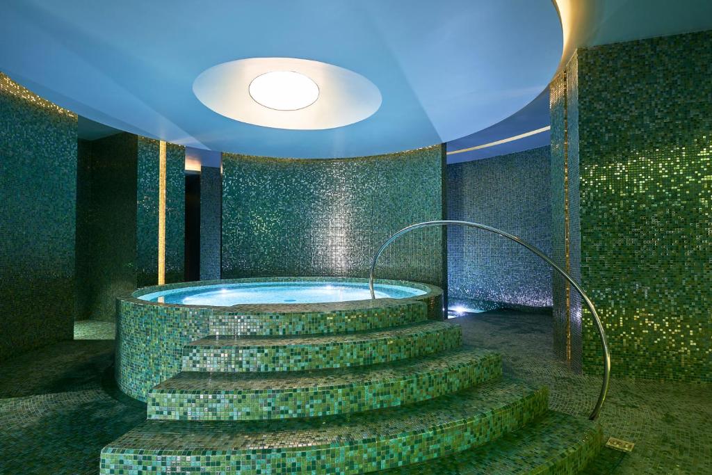 Mūsdienīgs spa ar zaļiem mozaīkas elementiem un relaksējošu burbuļvannu. Ideāla vide atpūtai un relaksācijai.