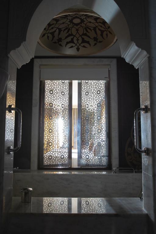 Eleganta vannas istaba ar greznu interjeru, kurā redzama rakstaina logu aizsargājoša paneļa struktūra, kas atspoguļo gaismu un telpas dziļumu.