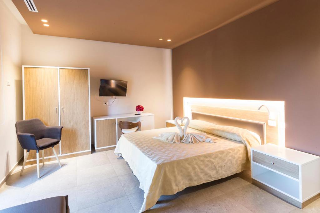 Mūsdienīgs viesnīcas numurs ar divguļamo gultu, televizoru un ērtu mēbeli, radot mājīgu atmosfēru. Gultas veļa veidota sirdī, piešķirot romantisku pieskārienu.