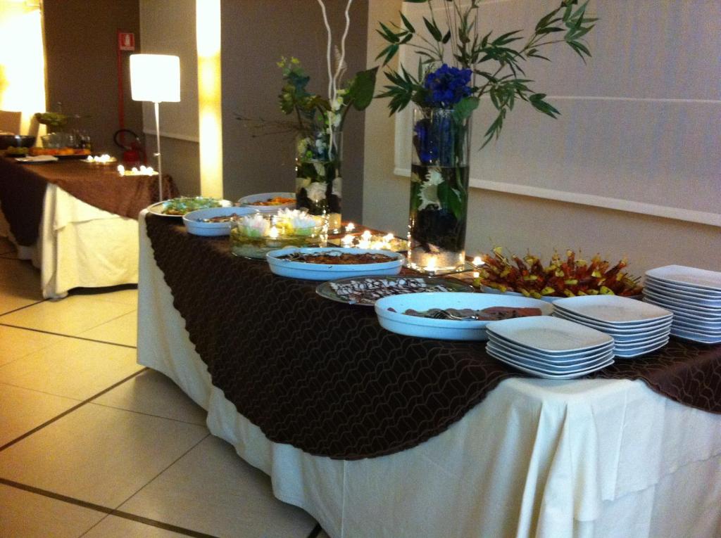 Bufete ar dažādiem ēdieniem un dekorācijām, ieskaitot ziedus un sveces, piemērota svinībām. Eleganta un viesmīlīga atmosfēra.