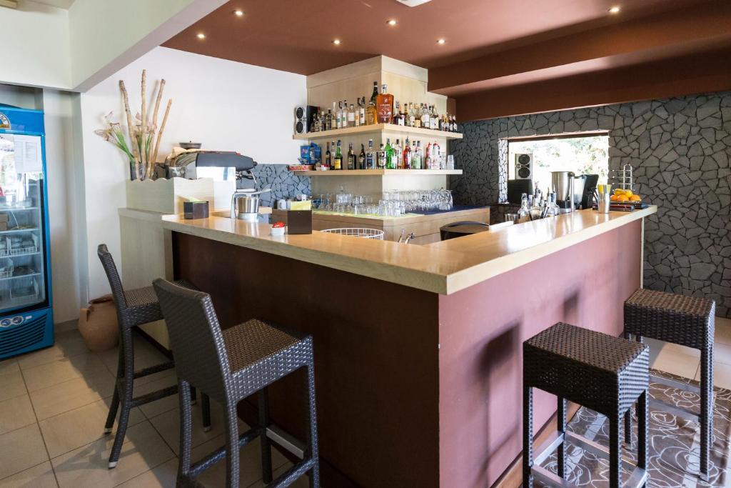 Mūsdienīgs bārs ar plašu alkohola izvēli, elegantu dizainu un komfortablām krēsliem, ideāli piemērots relaksācijai. Bāra stūrī redzama arī dzesētāja ar dzērieniem.