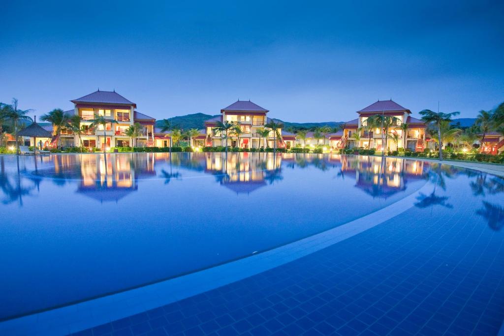 Tamassa Bel Ombre viesnīcas baseins piekrastē, apgaismots vakara stundās.