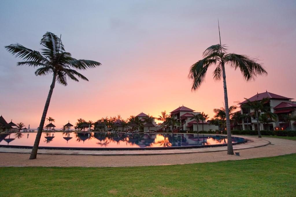 Saulrieta skats pie Tamassa Bel Ombre ar palmām un baseinu