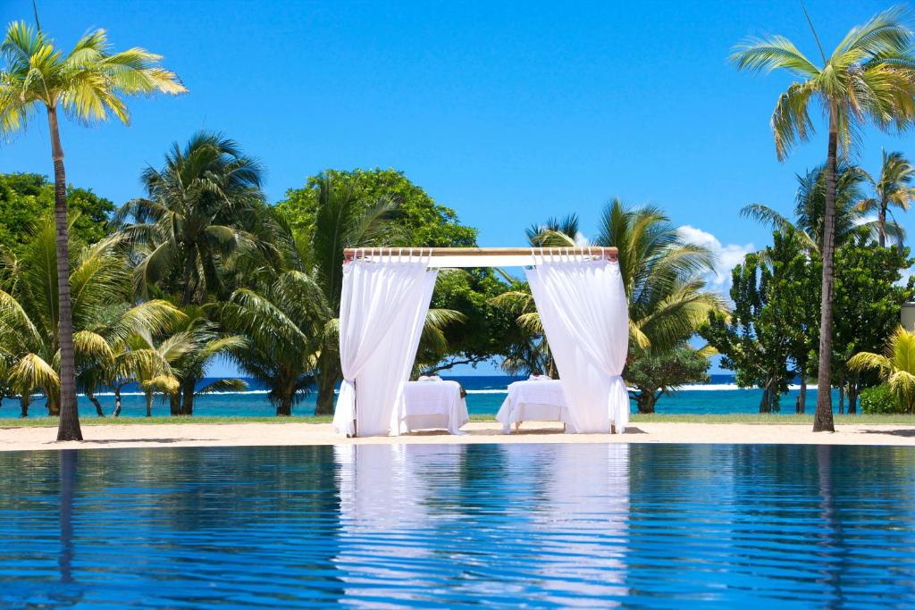 Romantiska atpūtas zona pie Tamassa Bel Ombre, ūdeni un palmas.