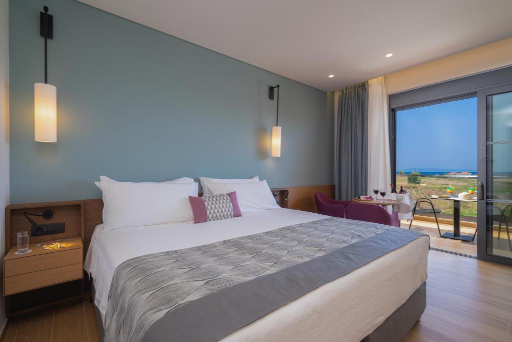 Mūsdienīgs viesnīcas numurs ar plašu gultu, modernu interjeru un skatu uz jūru. Numurā ir ērtas mēbeles, kā arī balkons ar galdu un krēsliem.