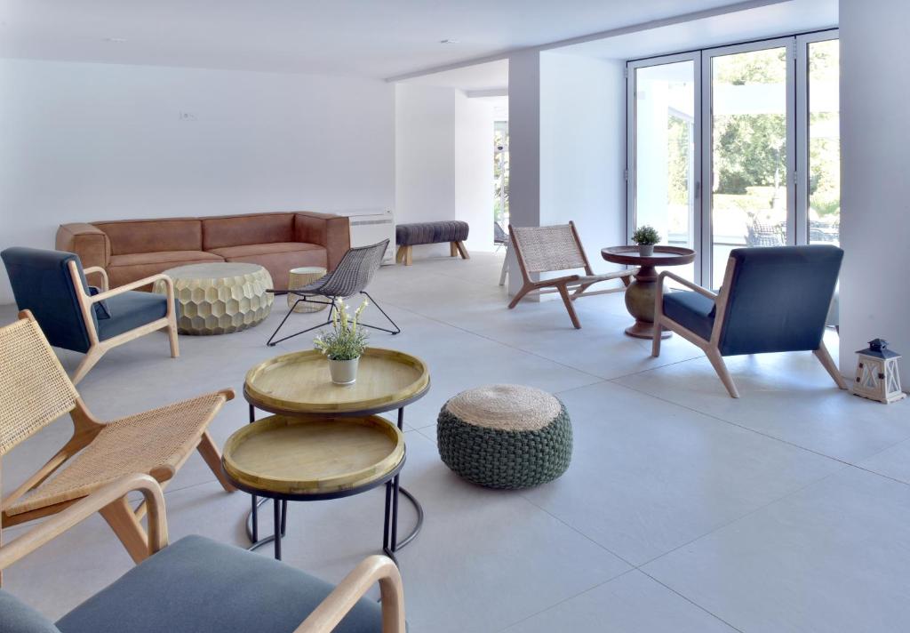 Mūsdienīga un gaiša telpa ar ērtiem krēsliem un dīvānu, kas veidota relaksācijai. Interjers izceļas ar dabīgiem materiāliem un modernu dizainu.