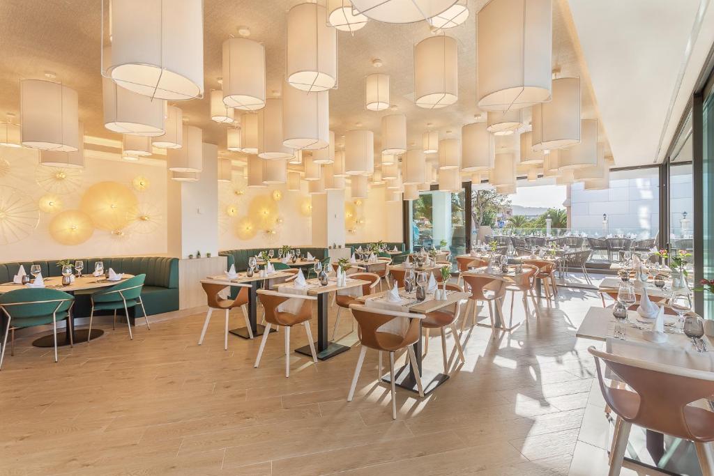 Mūsdienīgs restorāns ar elegantu interjeru, kas ietver stilīgas gaismas un komfortablus galdiņus. Telpa ir gaiša un aicinoša, radot patīkamu atmosfēru.