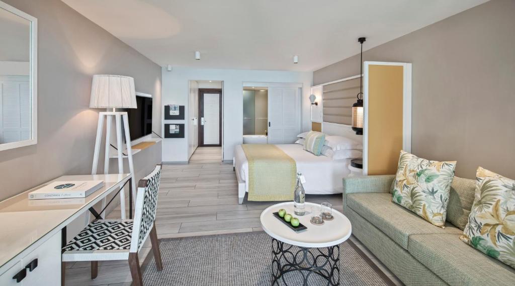 Mūsdienīgs viesnīcas numurs ar gaišām krāsām, ērtiem dīvāniem un galdu darbam. Numurā ir liels gultas zonas un atpūtas stūris, radot komfortablu atmosfēru.