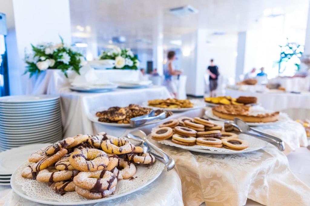 Saldumu galda ar dažādiem cepumiem un konditorejas izstrādājumiem, rotāti ar ziediem un servēti svinīgā vidē.