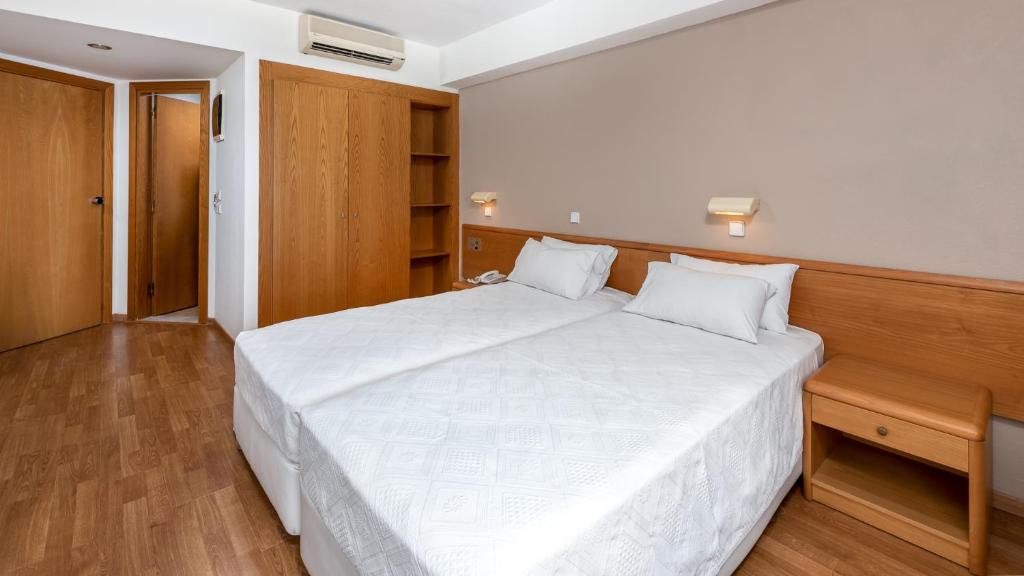 Mūsdienīgs viesnīcas numurs ar divām atsevišķām gultām, koka mēbelēm un siltu apgaismojumu. Numurā ir skapji un rakstāmgalds, radot patīkamu atmosfēru atpūtai.