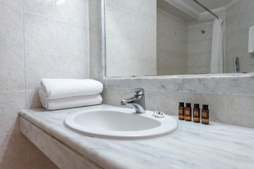 Vannas istaba ar marmora izlietni, baltām dvielēm un higiēnas līdzekļu komplektu.