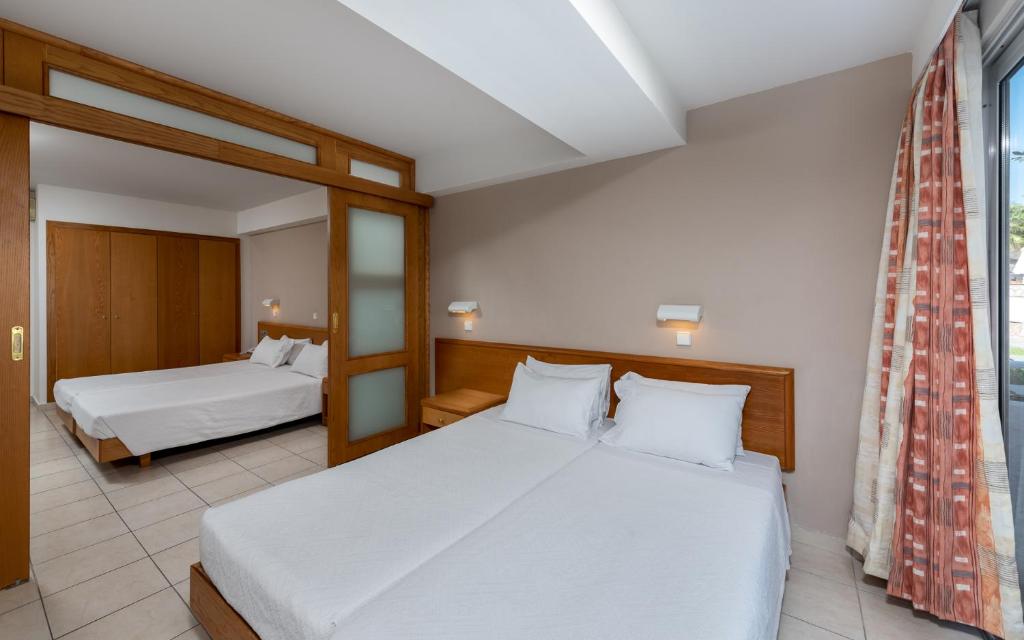 Gulamistaba ar diviem gultām, koka mēbelēm un dabiskiem apgaismojumiem, kas izveido mājīgu atmosfēru. Logi ar aizkariem, kas nodrošina privātumu un gaismas kontroli.