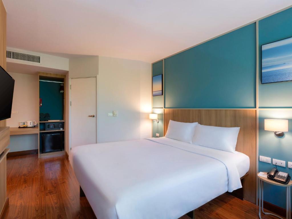 Mūsdienīgs viesnīcas numurs ar plašu gultu, koka grīdu un gaišiem toņiem, kas rada komfortablu atmosfēru. Numurā ir televizors, mini ledusskapis un uzglabāšanas vietas.