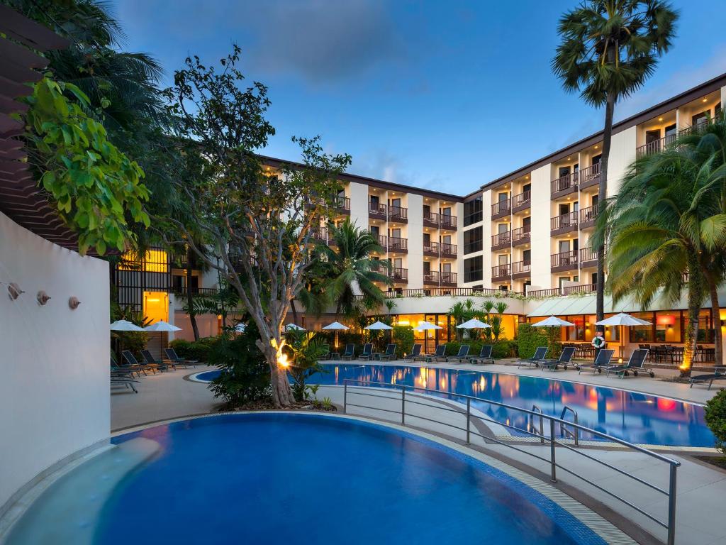 Luksusa viesnīca ar baseinu un palmām, kas radīta atpūtai un relaksācijai. Vides apgaismojums un eleganta arhitektūra papildina šo mierīgo atmosfēru.