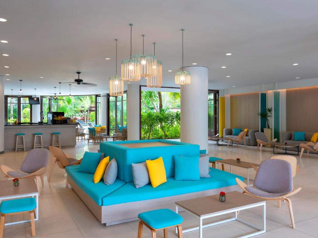 Mūsdienīgs viesnīcas vestibils ar gaišām krāsām un ērtu mēbelējumu, kurā redzams gaišs, atvērtas telpas dizains ar dabiskiem elementiem. Ideāla vieta relaksācijai un socializācijai.