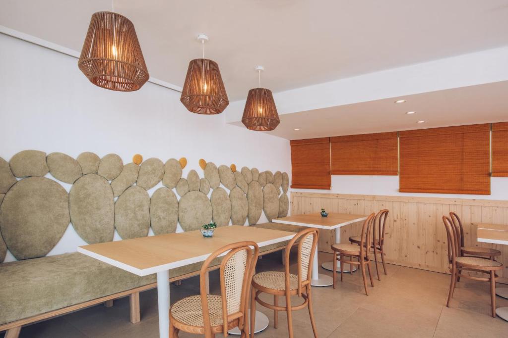 Mūsdienīgs kafejnīcas interjers ar zaļām apmales un siltu apgaismojumu, kas rada patīkamu atmosfēru. Koka mēbeles un rūpīgi izvēlēti dekoratīvie elementi piešķir telpai unikālu šarmu.