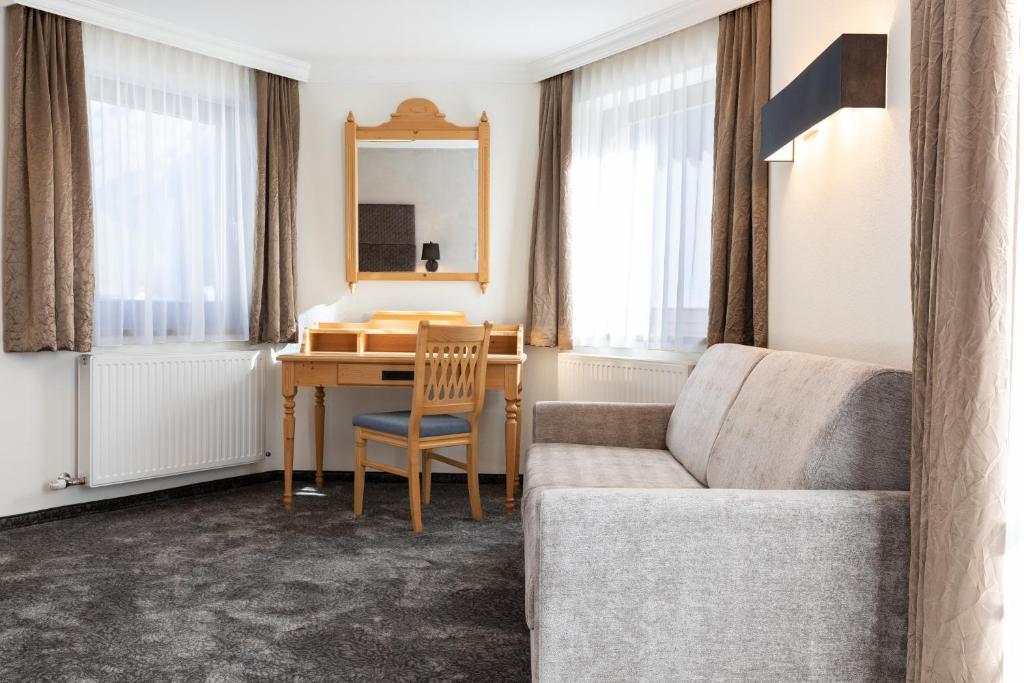 Mūsdienīgs viesnīcas numurs ar dīvānu, rakstāmgaldu un lieliem logiem, kas nodrošina dabisko apgaismojumu. Interjers ir elegants un ērts, ar mīkstiem toņiem un stilīgām aizkariem.