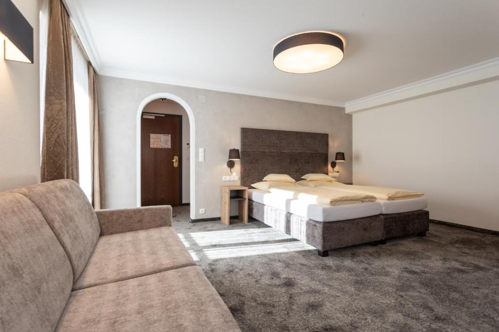 Mūsdienīgs viesnīcas numurs ar divvietīgu gultu, dīvānu un dabīgu apgaismojumu. Interjers ir elegants un ērts, ideāls relaksācijai.