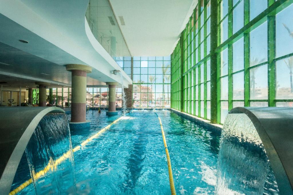 Iekštelpu peldbaseins ar lieliem logiem, caur kuriem ieplūst dabiska gaisma, un ūdens strūklām. Moderns dizains un zaļi akcenti radījuši relaksējošu atmosfēru.