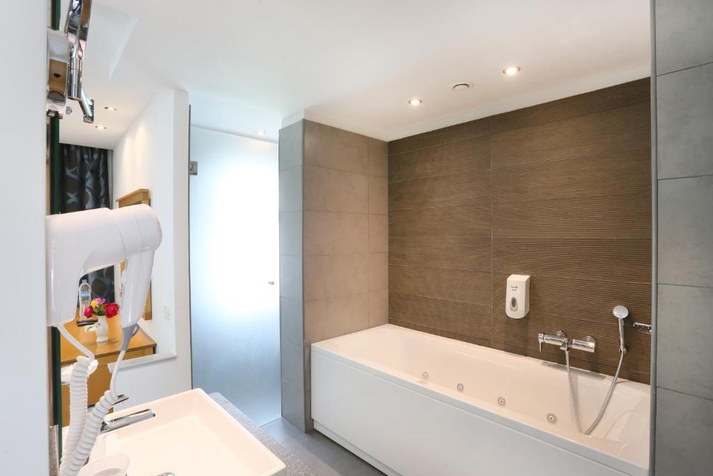 Sentido Apollo Palace viesnīcas moderna vannas istaba ar vannu.